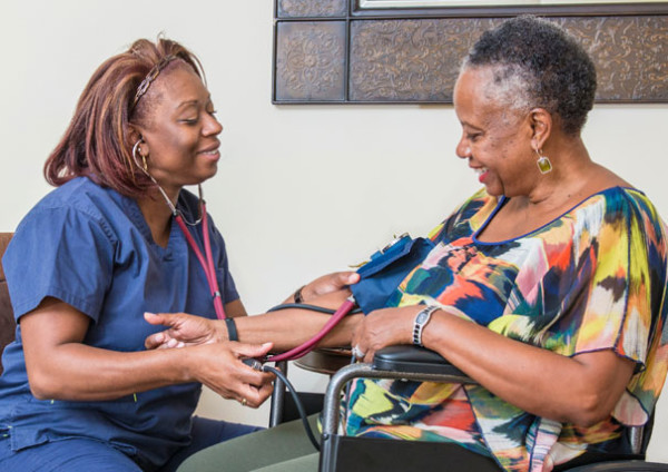 Nursing Taking Woman's Blood Pressure